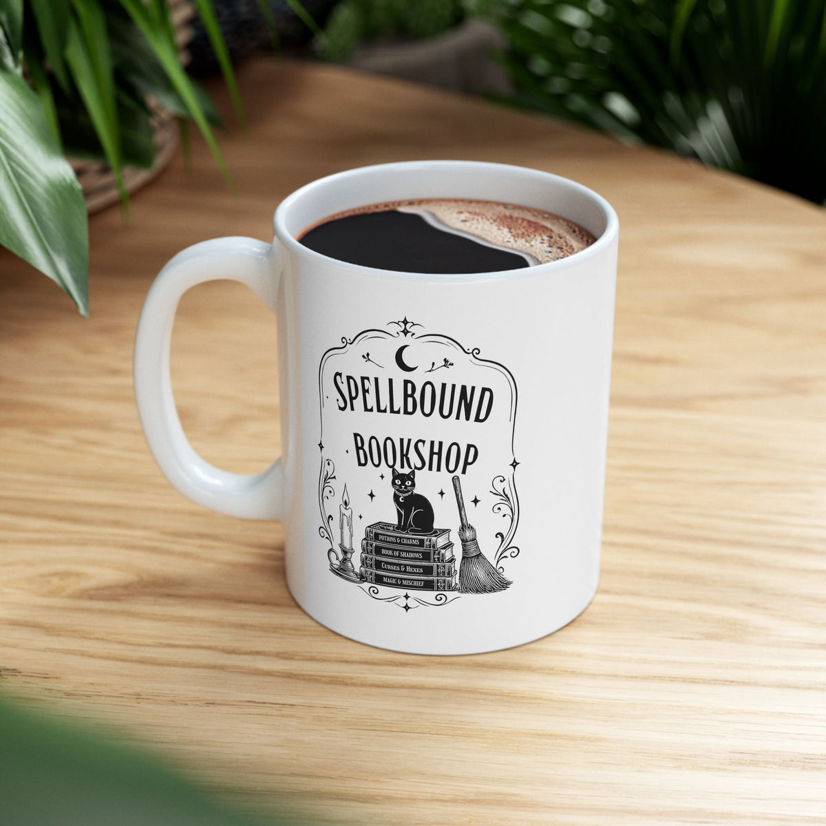 Spellbound Bookshop ceramic mug with a black cat on stacked spell books