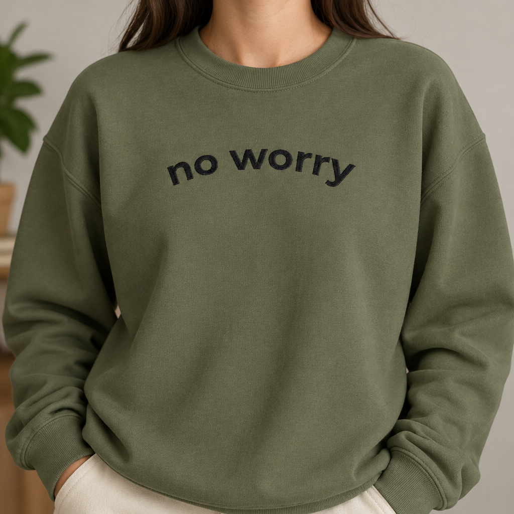 Close-up of the military green No Worry crewneck with arched no worry lettering