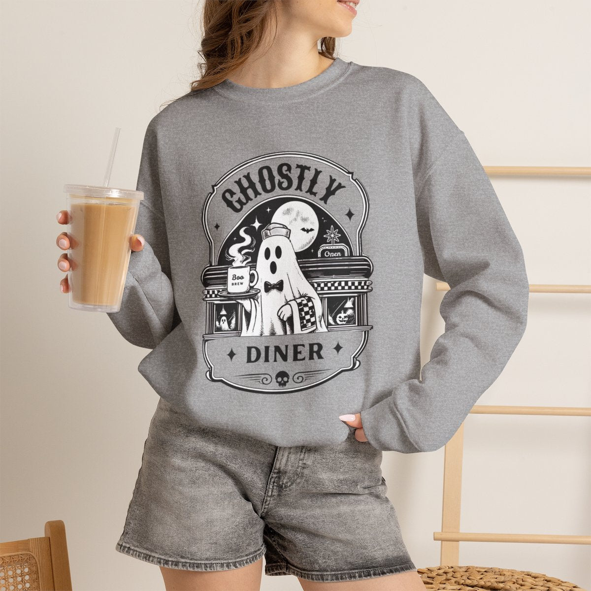Lifestyle photo of the Ghostly Diner sweatshirt in a fall setting