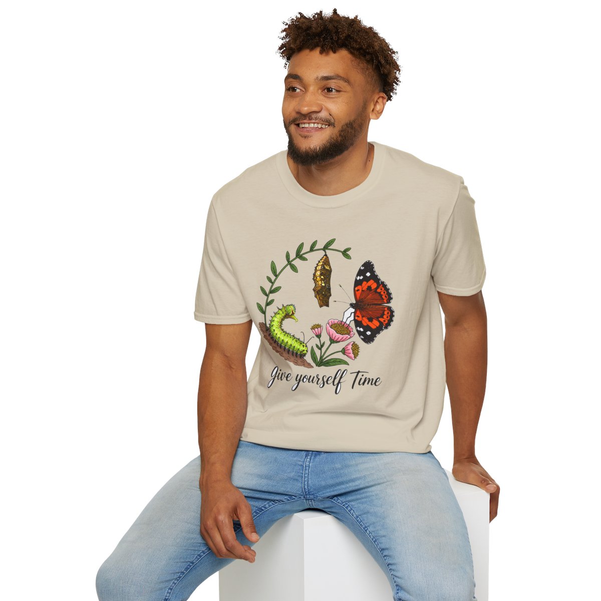 Man sitting wearing the sand Give Yourself Time butterfly transformation tee