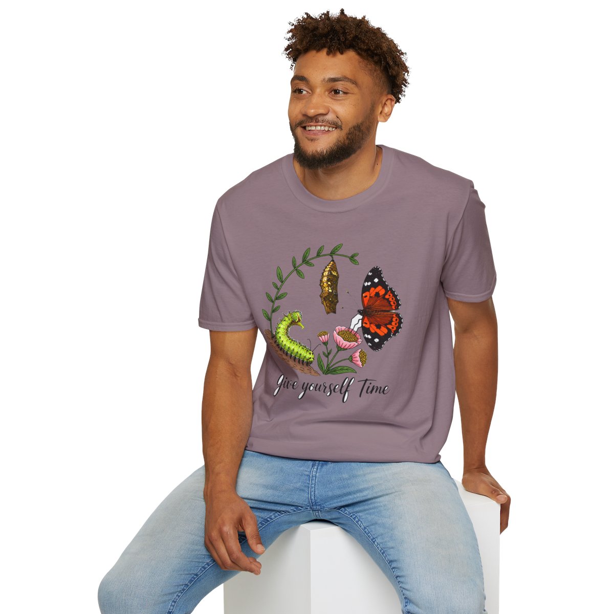 Man sitting wearing the paragon Give Yourself Time butterfly transformation tee